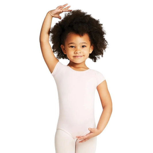 Young girl in a white leotard posing with one arm raised on a white background