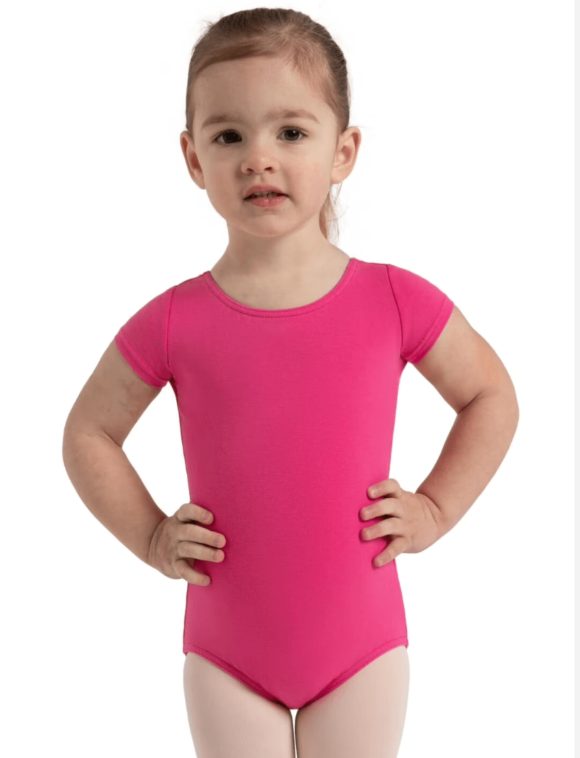 Child wearing a bright pink leotard on a white background