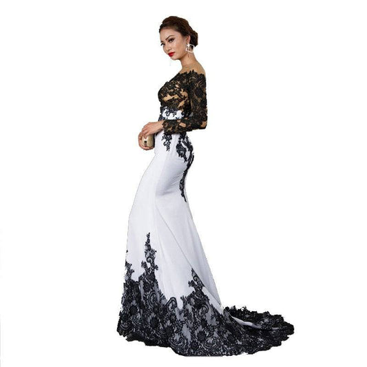 Woman wearing a black and white lace evening gown on a white background